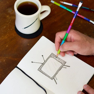 Hand holding a Blackwing Volume 343 pencil above a sketchbook with TV illustration