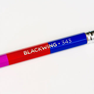 Close-up Blackwing Volume 343 pencil with blue barrel and multicolor label strip