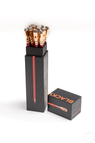 Pencil set in a black tray with sharpened red-tipped pencils and boxed packaging