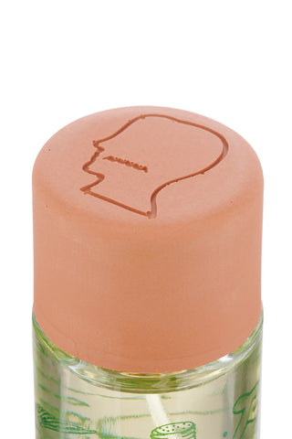 Perfume bottle cap in muted peach with embossed line design