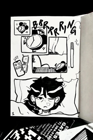 Open black-and-white zine spread with illustrated cat face and comic panels