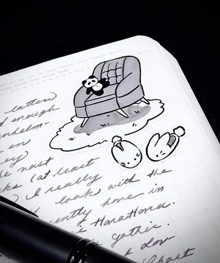 At-home sticker close-up: line-art animal on bed with handwritten-style script accents