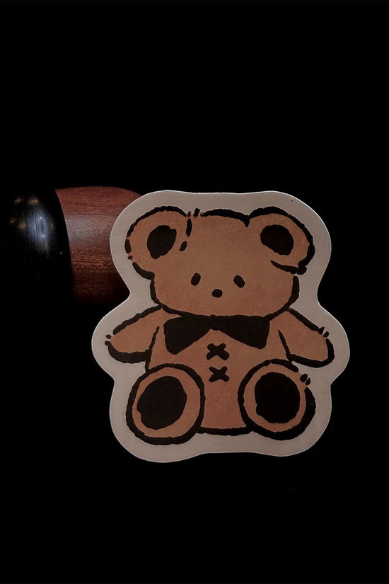 Cute cartoon bear vinyl sticker with bow tie, outlined in black
