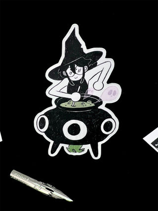 Cartoon witch cauldron sticker with purple potion bubble and green spell scroll
