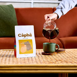 Càphê Roasters Vietnamese Espresso Blend coffee bag beside a mug being filled with coffee