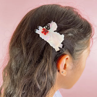 Sheep-shaped hair clip with iridescent white body, black face, and red bow