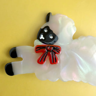 Sheep hair clip ornament in iridescent white with black face and red bow detail
