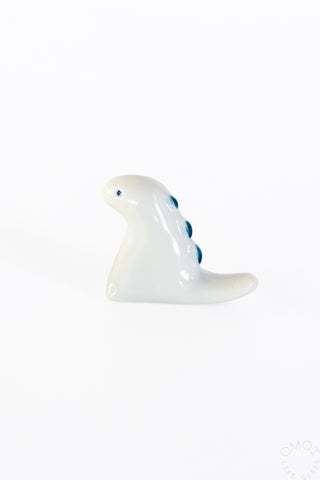 White ceramic tyrannosaurus chopstick rest, side view