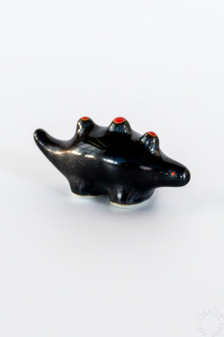 Black ceramic stegosaurus chopstick rest, angled top view