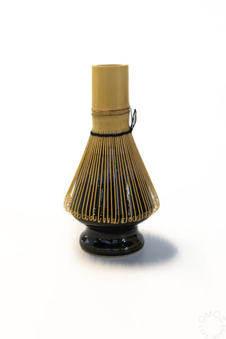 Ceramic matcha whisk stand with upright bamboo chasen whisk and black base