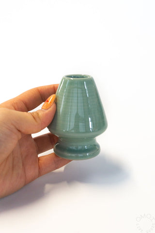 Seiji matcha whisk stand in glossy dark green, held by hand