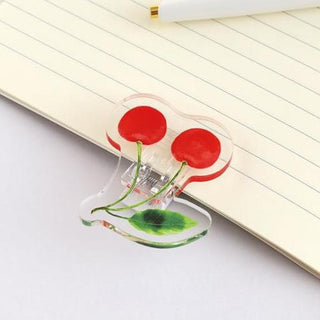 Cherry motif acrylic paper clip with two red cherries on lined paper