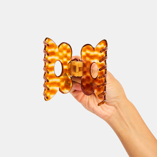 Honey tortoiseshell flower claw hair clip with visible teeth and center opening.