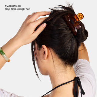 Honey tortoiseshell flower claw clip holding straight hair up near the top.