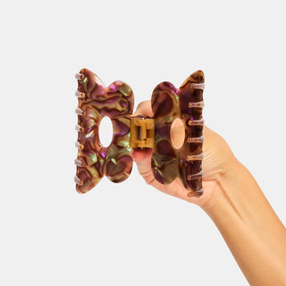 Purple marbled hair claw clip open, showing inner hinge and prongs