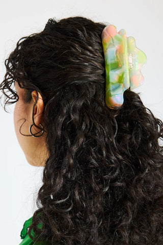 Pastel jelly claw clip in dark curly hair, curved translucent claws