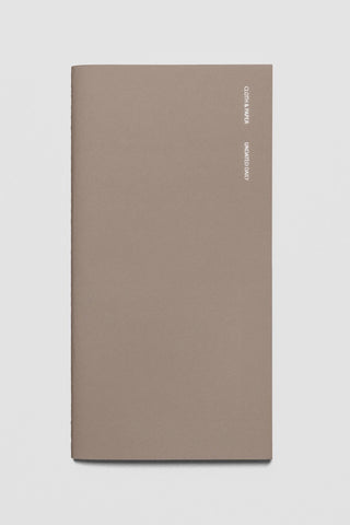 A5 slim travel notebook with brown cover, daily lined pages and minimal spine text.