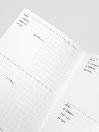 A5 notebook open at angle showing grid and fields for name, category, location