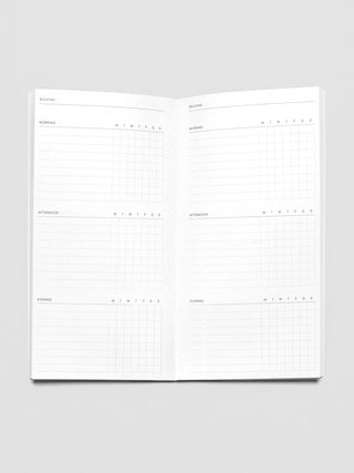 Open A5 slim travel notebook showing two-page routine planner grid