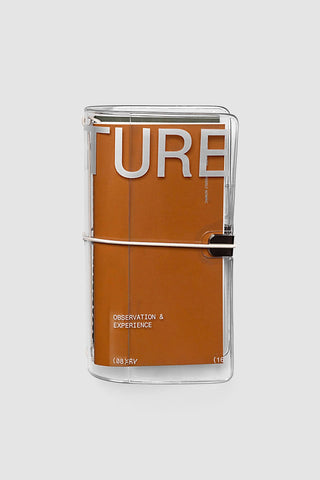 Clear vinyl travel notebook cover with orange insert and black elastic closure