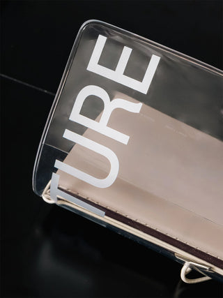 Clear vinyl travel notebook cover with white lettering and metal binder rings, angled