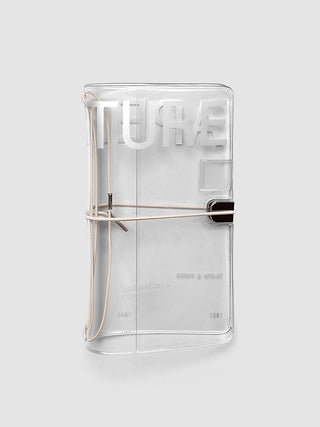Clear vinyl travel notebook cover with aperture pocket and black elastic strap, closed