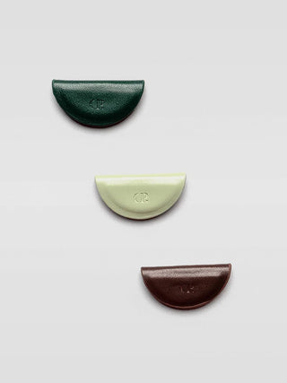 Three mini magnetic bookmark halves in dark green, pale yellow-green, and dark brown