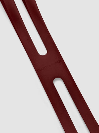 Burgundy notebook closure band with long oval slot and round cutout