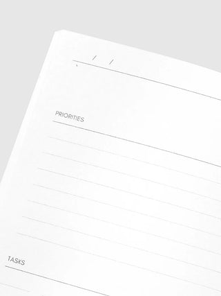 White daily planner notebook page with 'PRIORITIES' and 'TASKS' headings