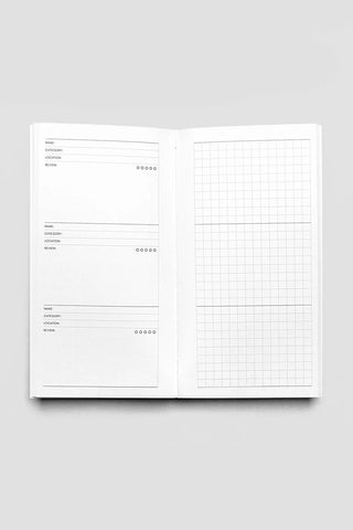 Open travel notebook with left list sections and right grid planning page