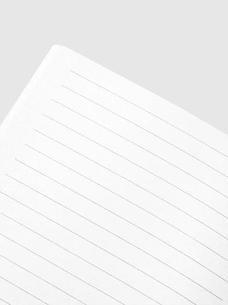 Close-up of lined notebook pages with gray horizontal lines