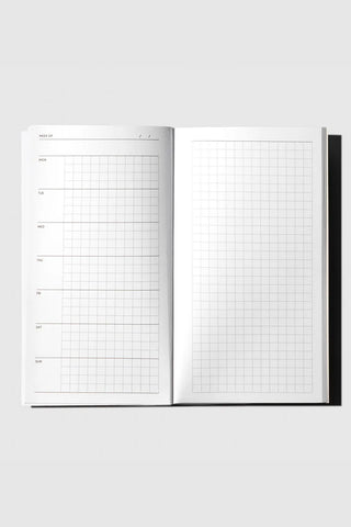 Open weekly graph travel notebook with grid pages and left-right weekly panels
