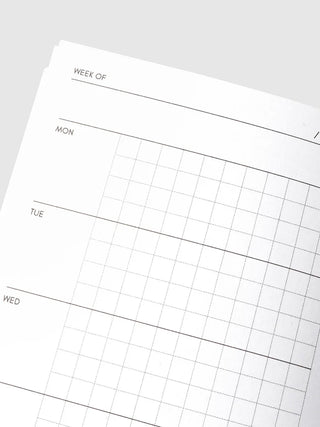 Travel notebook weekly planner with 'Week of' header and day sections on graph