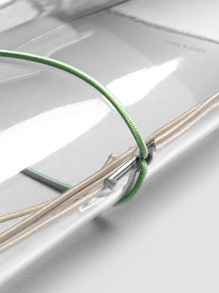 Close-up of vinyl travel cover with green band, clear strap, and metal clasp