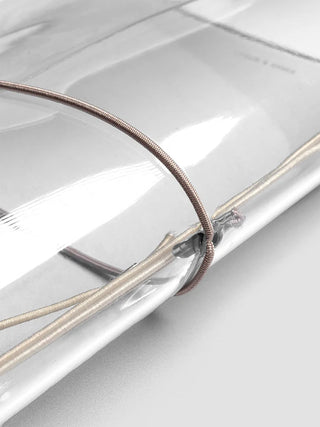 Close-up of vinyl travel cover with bronze cords, clear strap, and metal clasp