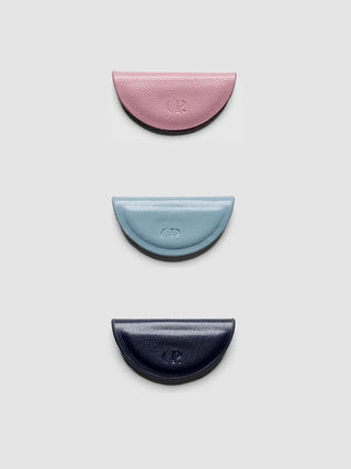 Mini magnetic bookmarks in pink, light blue, and navy crescent shapes with embossed logo
