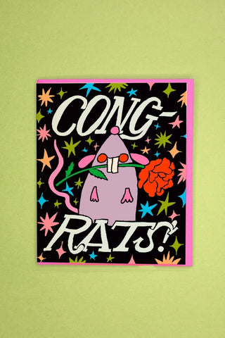Greeting card: "CONG-RATS!" text with cartoon unicorn on dark cover