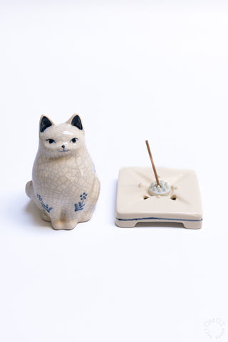 Crackle porcelain cat incense burner figurine beside square incense holder