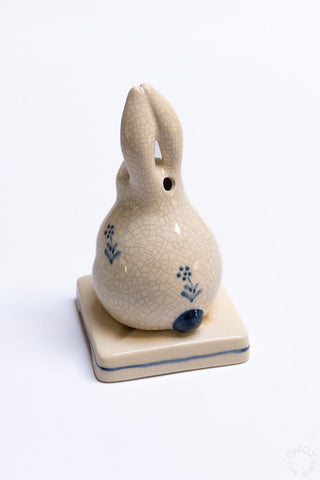 Side view of crackle porcelain rabbit incense burner with blue floral details and side opening