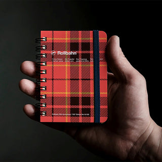 Red plaid mini memo notebook with black spiral binding, held in a hand