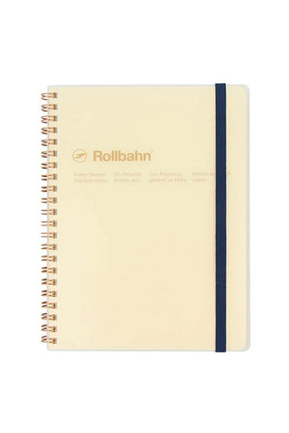 Clear spiral notebook with cream cover, gold rings, and navy elastic strap