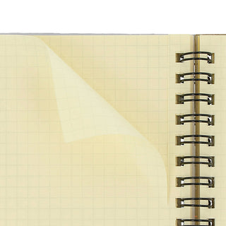 Graph paper pages in cream spiral notebook with gold rings