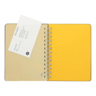 Open pocket memo spiral notebook with yellow covers and metal rings, card insert