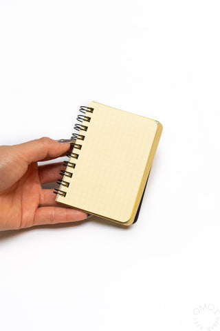 Mini spiral memo notebook with blue elastic band, light tan cover