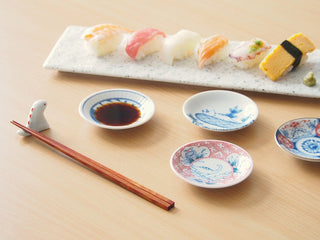 Set of mini ceramic plates with blue seigaiha and dino designs, on table