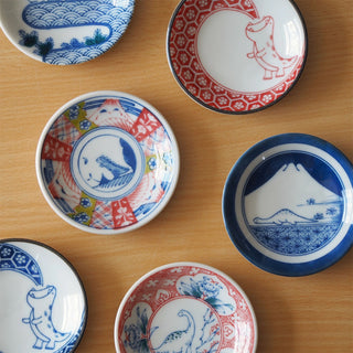 Collection of small ceramic mini plates featuring dino and wave motifs in blue and red