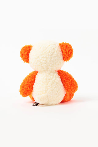 Orange-and-white plush panda toy, seated side view with small metal tag