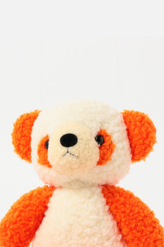 Orange-and-white plush panda face close-up with black eyes and nose