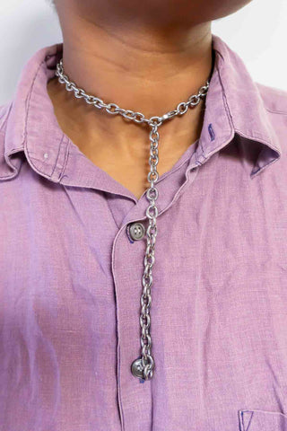 Layered silver-tone chain necklace with hanging charm pendant and small face detail