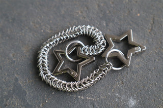 Silver star-maille chain with two dark star charms on metal clasp clips
